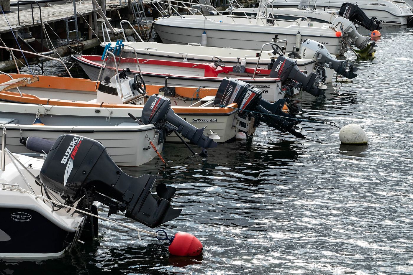 Outboard motors on boats at a dock. Photo: W.carter, CC0, via Wikimedia Commons.